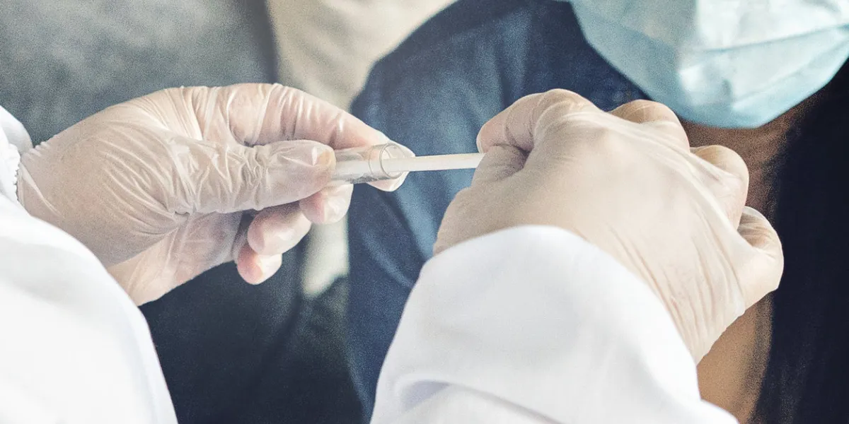 a doctor in a protective suit performs a coronavirus test for the covid-19 viruspandemic concepts