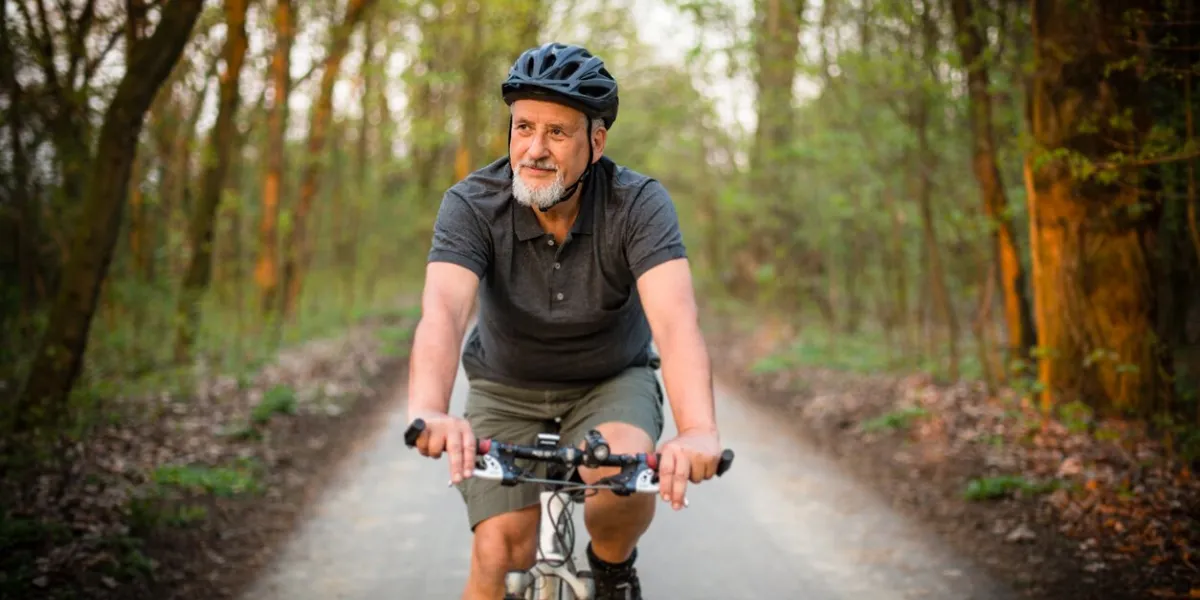 senior man on his mountain bike outdoors in forest on a lovely summer day, staying active