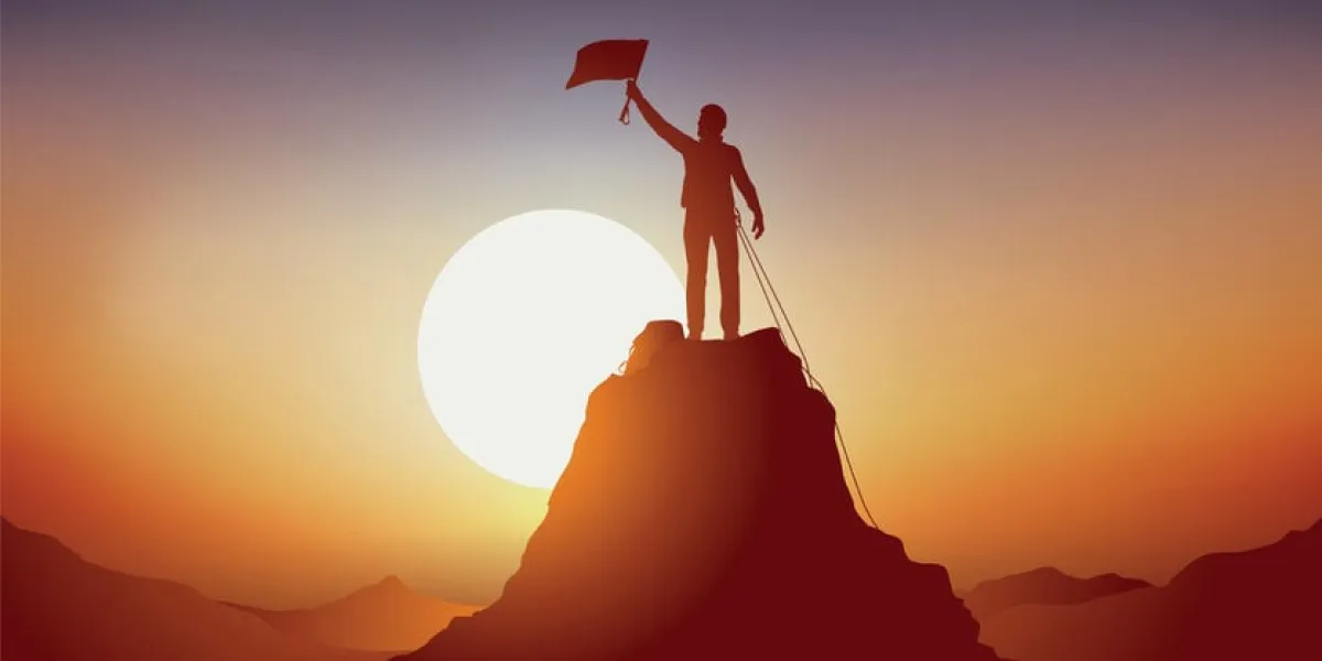 concept of the sporting feat, with a winning mountaineer at the top of a mountain, waving a flag as a sign of victory