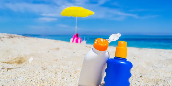 detail of suntan lotion bottles on the sand