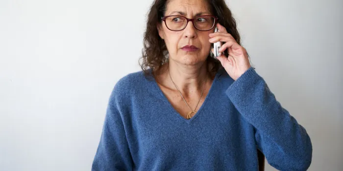 senior phone fraud concept mature woman distrusting phone call