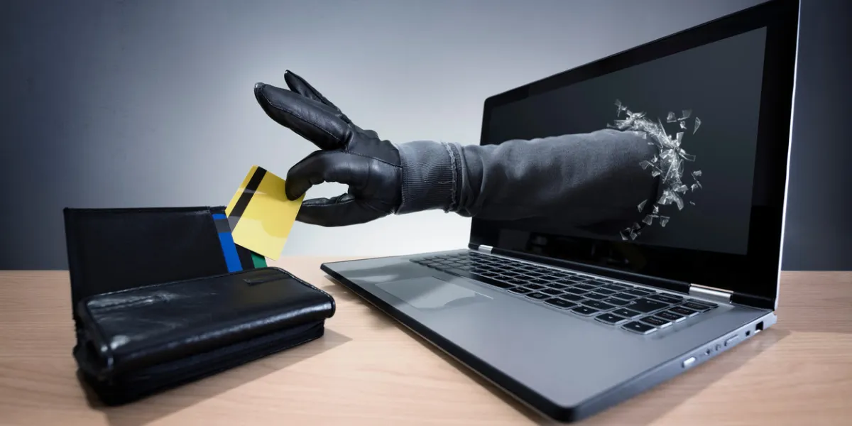 stealing a credit card through a laptop concept for computer hacker, network security and electronic banking security