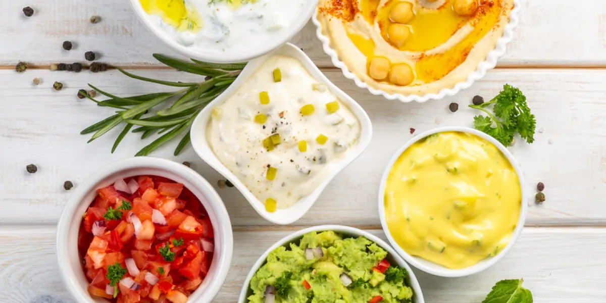 selection of sauces in white bowls on white bowls, top view