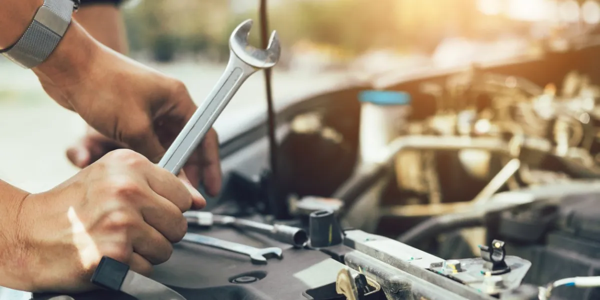 car mechanic is holding a wrench ready to check the engine and maintenance