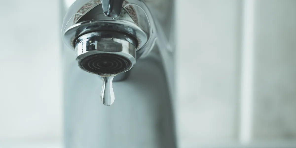 water drop dripping from the tap and water shortage