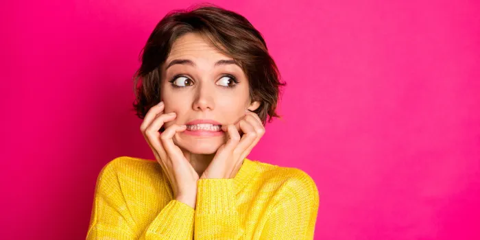 portrait of frustrated anxious afraid girl look copyspace see she made, horrible mistake bite finger nails wear sweater isolated over bright color background