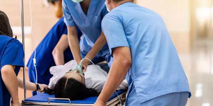 medical team do cpr cardiopulmonary resuscitation to seriously injured patient with oxygen mask while push gurney stretcher bed to operating room emergency health care and medical hospital concept