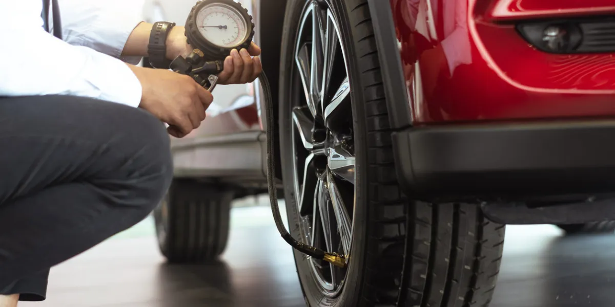 asian man car inspection measure quantity inflated rubber tires carclose up hand holding machine inflated pressure gauge for car tyre pressure measurement for automotive, automobile image