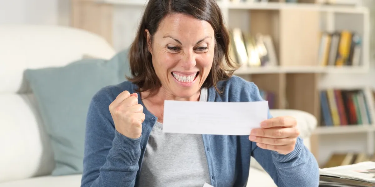 excited adult woman checking receipts at home