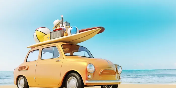 small retro car with baggage, luggage and beach equipment on the roof, fully packed, ready for summer vacation, concept of a road trip with family and friends, dream destination, very vivid colors with dominant blue sky and ocean and bright orange car