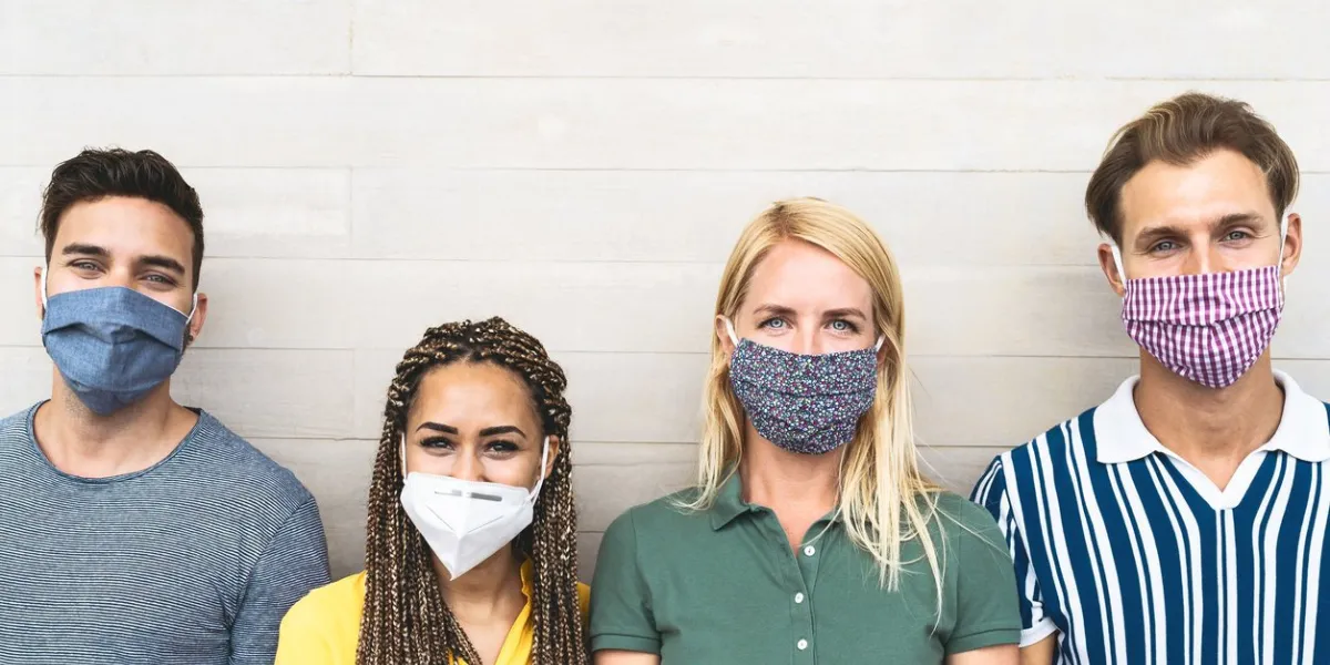multiracial friends wearing face mask for preventing and stop corona virus spread - youth millennial generation lifestyle during covid-19 crisis
