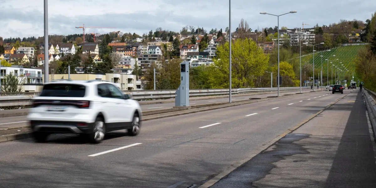 road traffic speed trap camera in a gray box between 4 lanes of road in a major european city blurred traffic, slow shutter speed, no people