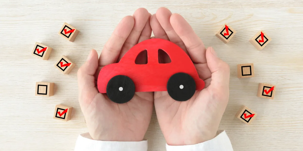 car toy covered by human's hands surrounded by wooden blocks with checking marks