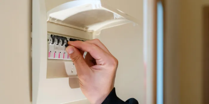 hand switching power switch on a fusebox close up of electrician checking fuse box knob