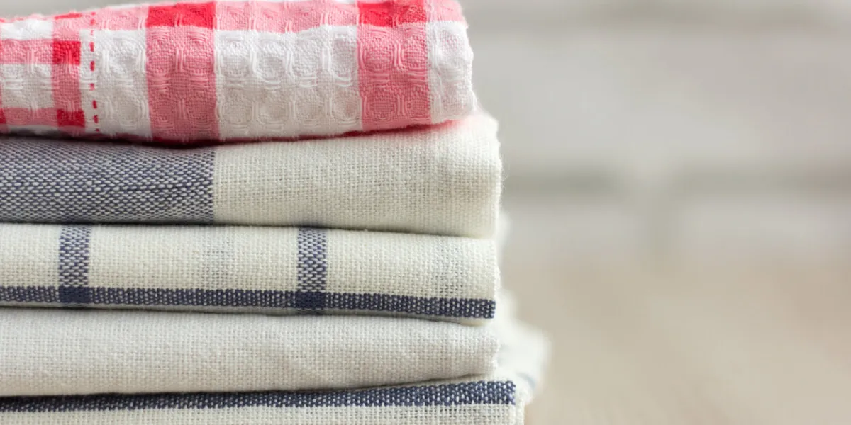 kitchen towels stacked on a light background with a copy of the space