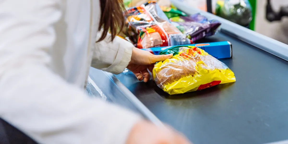 woman put products on the line near cashbox grocery shopping concept