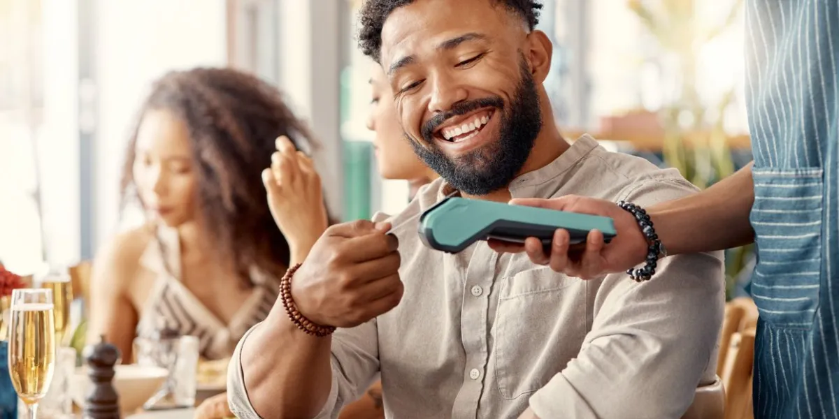 shot of a young man using a nfc card machine to make an online payment