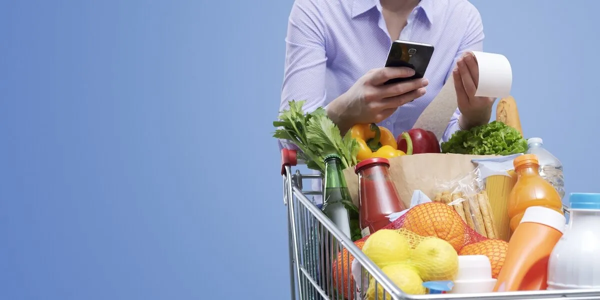 woman checking the grocery receipt using her smartphone