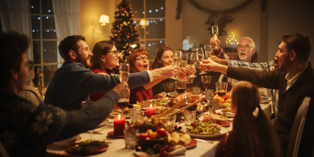 portrait of a handsome young black man proposing a toast at a christmas dinner table family and friends sharing meals, raising glasses with champagne, toasting, celebrating a winter holiday