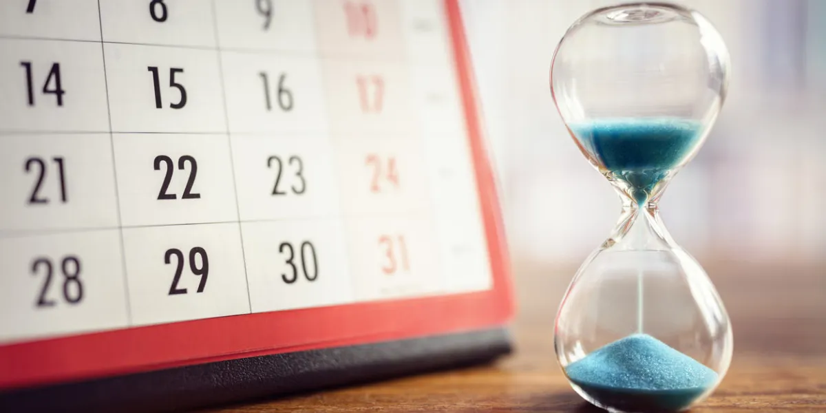hour glass and calendar concept for time slipping away for important appointment date, schedule and deadline