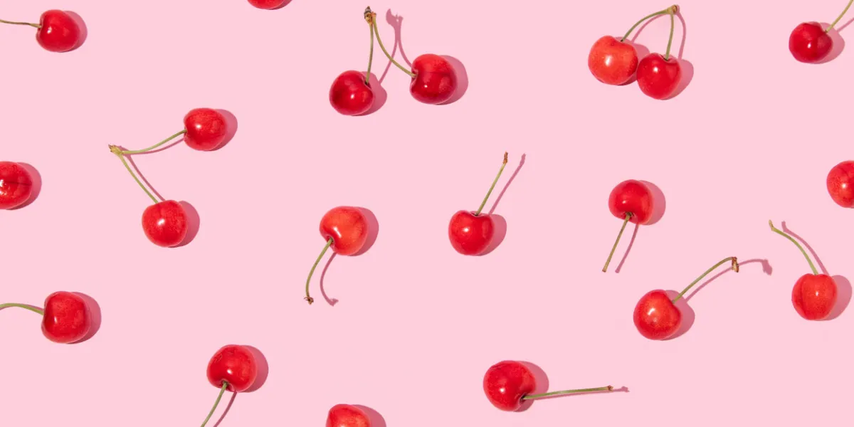 creative pattern made with bright red cherries on pastel pink background summer fruit idea trendy summer fruit concept minimal flat lay