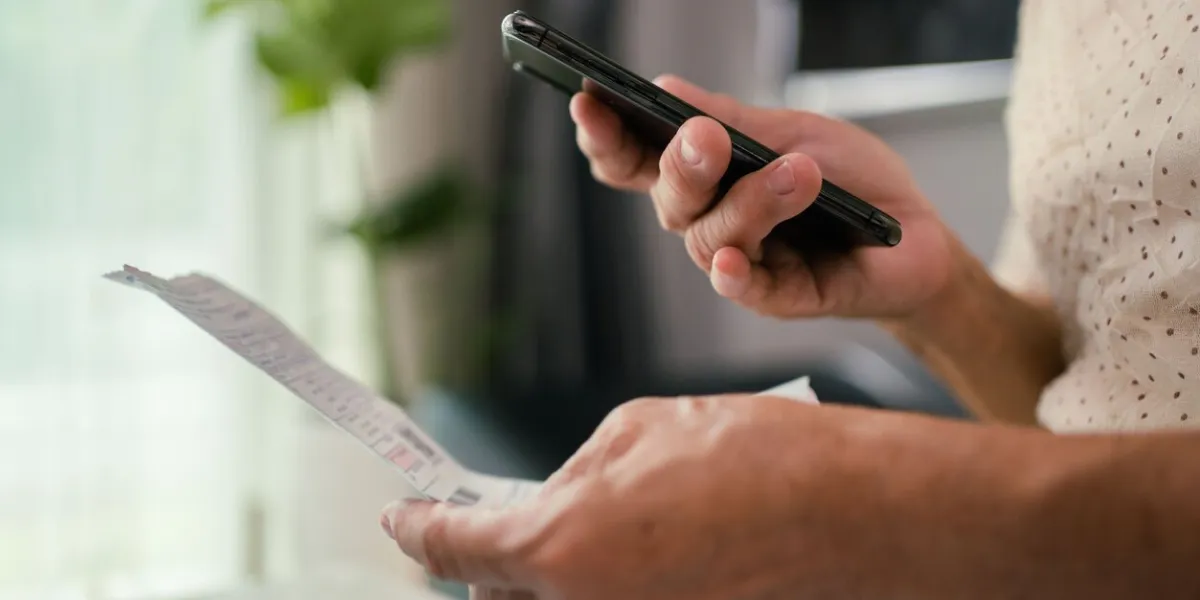 senior woman holds various expense bills and plans for personal finances in the living room in her home stock video