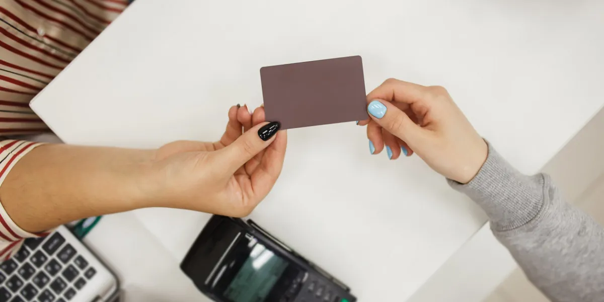 closeup of customer in the store giving credit card to seller