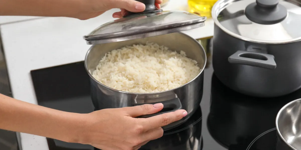 woman cooking rice on stove in kitchen