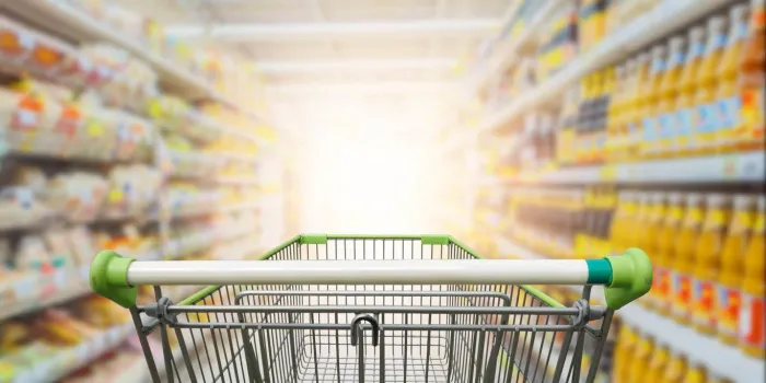 supermarket aisle with empty green shopping cart
