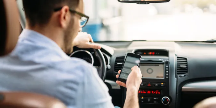 transportation concept - man using phone while driving the car