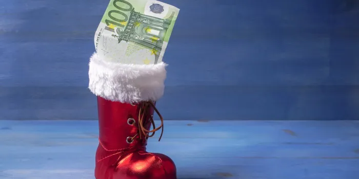 a santa's boot with a banknote as a christmas present