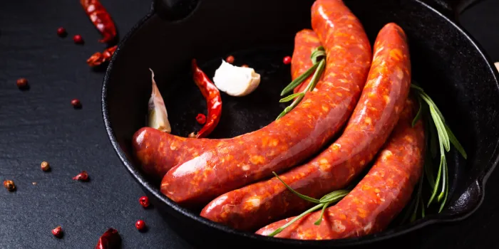 food concept merguez french spicy sausages in skillet iron pan with copy space