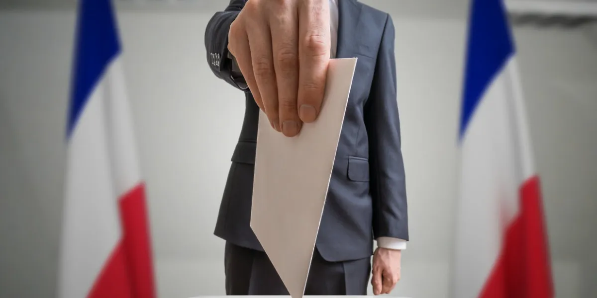 election in france voter holds envelope in hand above vote ball wide angle shot