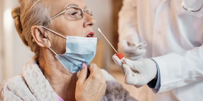 close-up of elderly woman getting pcr test at nursing home