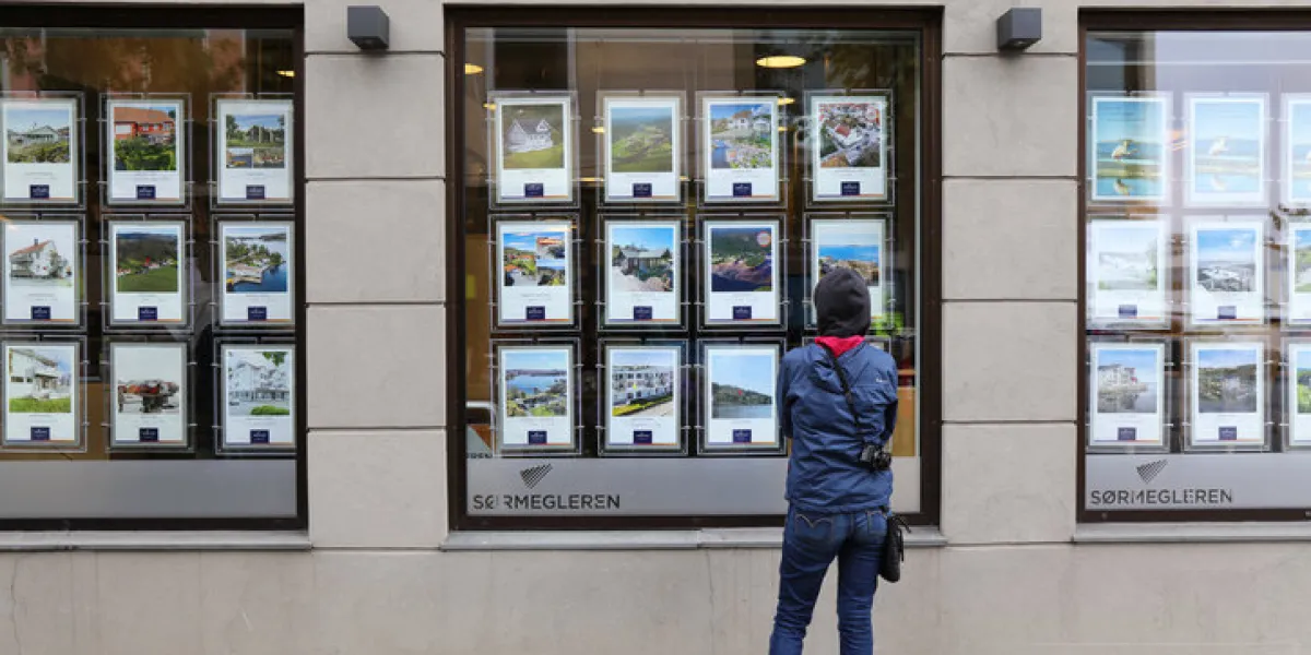 person analyzes real estate offers of a real estate agency window in town of mandal in vest-agder county of norway