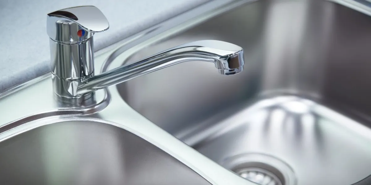 close up shot for the clean chrome tap and washbasin in a kitchen