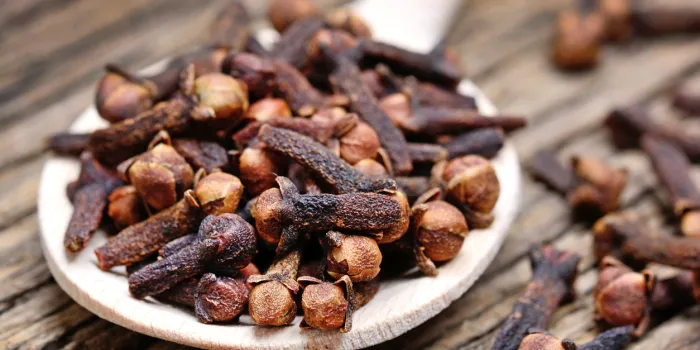 close up of clove in a wooden spoon on old table