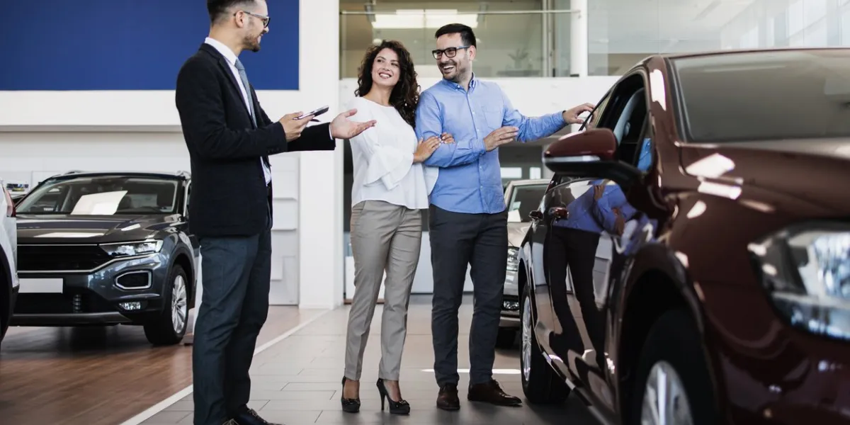 middle age couple choosing and buying car at car showroom car salesman helps them to make right decision