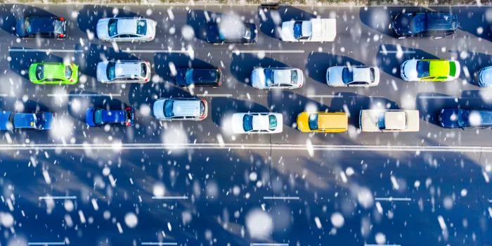 aerial car traffic during the snowfall slippery road top view from drone