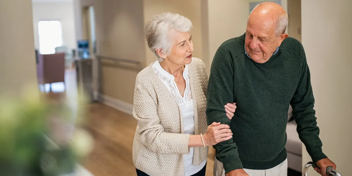 elderly woman help her husband walking using walker in nursing home senior woman helping disabled man with walking frame lovely wife holding hands of old husband in care centre