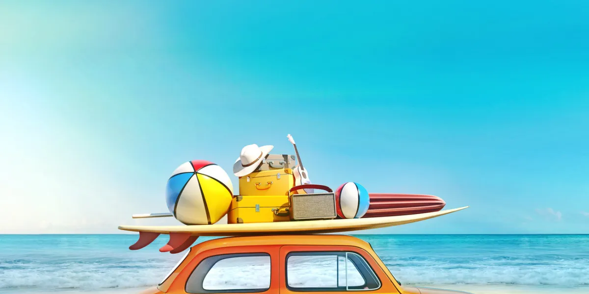 small retro car with baggage, luggage and beach equipment on the roof, fully packed, ready for summer vacation, concept of a road trip with family and friends, dream destination, very vivid colors with dominant blue sky and ocean and bright orange car