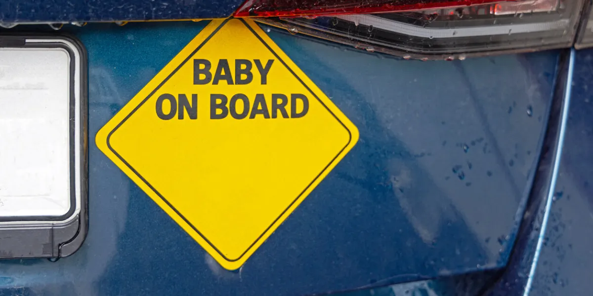 yellow warning sticker baby on board at car