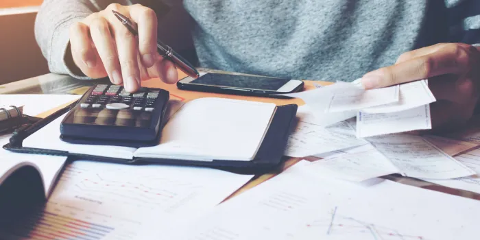 man using calculator and calculate bills in home office
