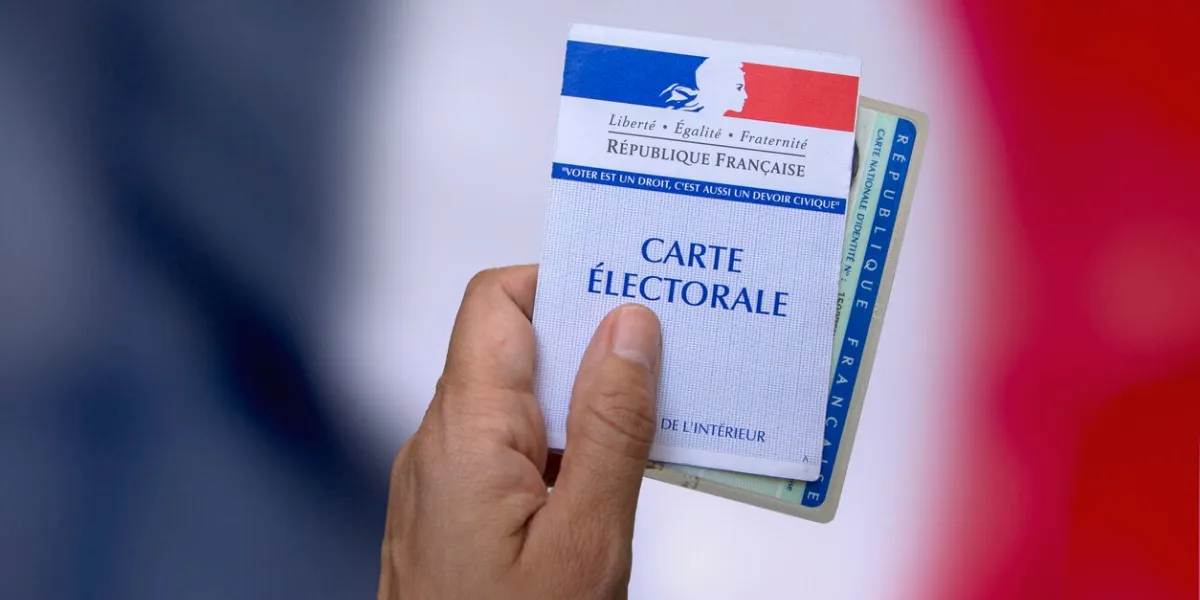 hand who holds an electoral card and an identity card to vote