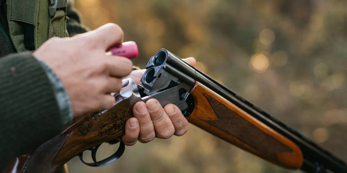 hunter man loading his gun while hunting outdoors hunting season concept