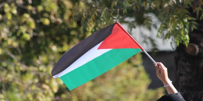 muslim woman waving the palestinian flag