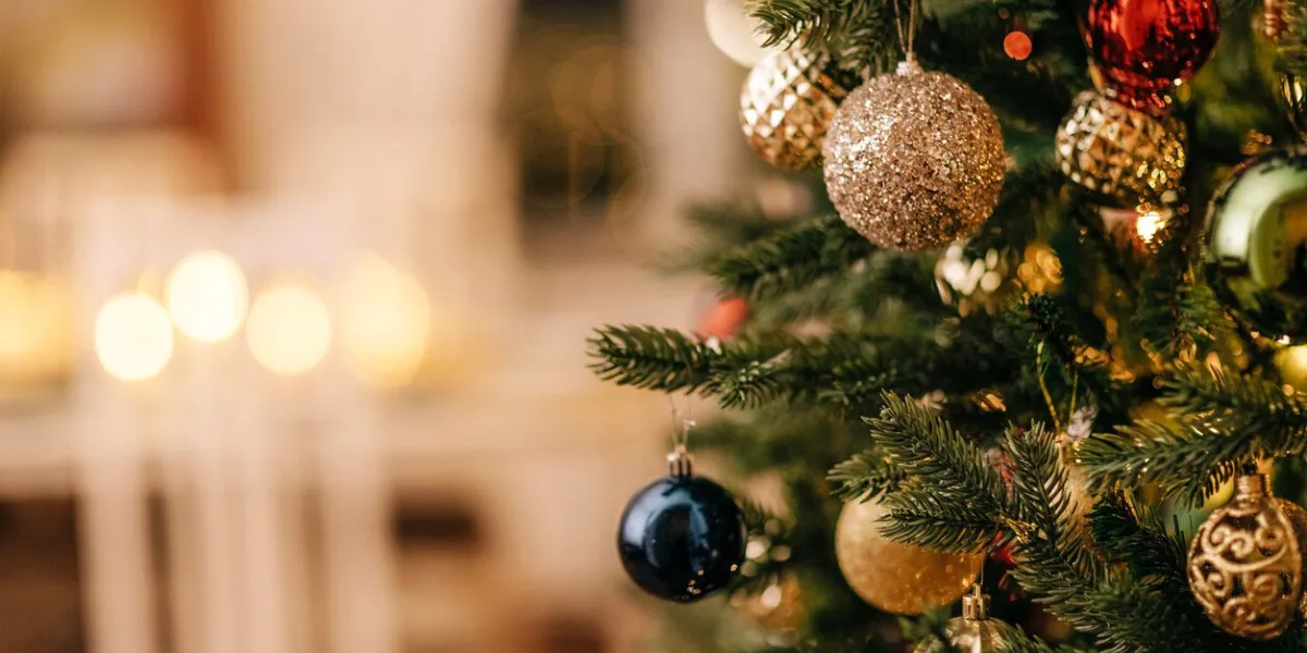 a close-up of a decorated christmas tree with vintage glass toys stylish rich interior with fireplace and lighted candles new year decorations copy space