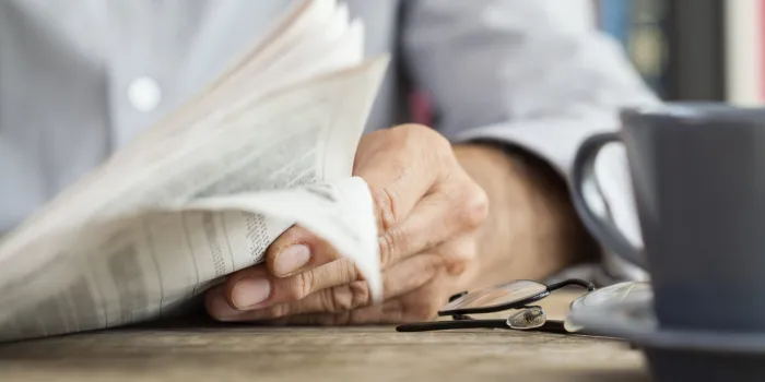 man newspaper reading on table