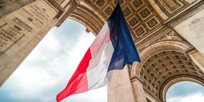 the flag of france at the arc de triomphe monument during bastille day